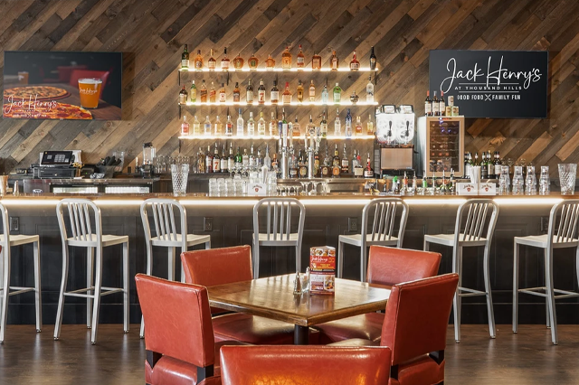 Jack Henrys bar with back lit shelves and warm inviting seating