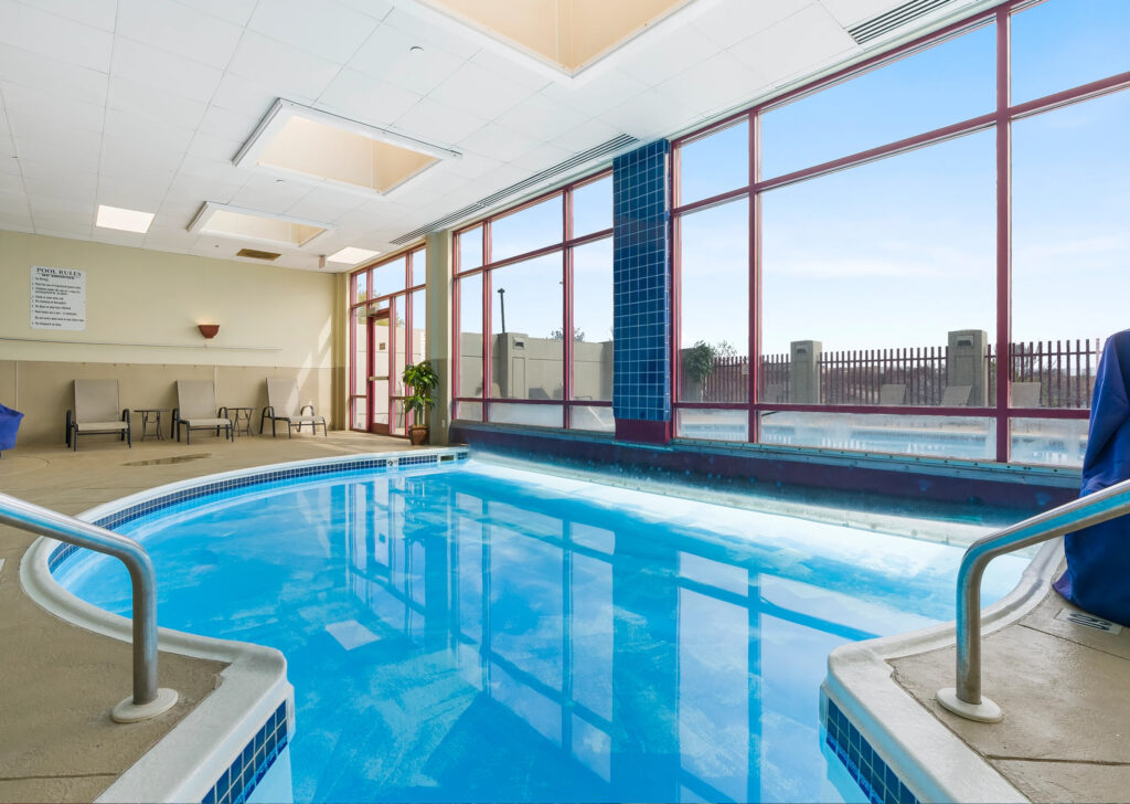 Indoor pool with hot tub and accessible seat